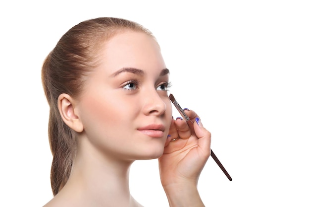 Aplicar maquillaje para modelo de belleza con paleta de sombras de ojos, aislado sobre fondo blanco.