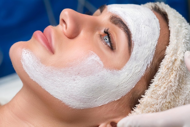 Aplicar una máscara en la cara en un salón de belleza Cosmetólogo y procedimiento de rejuvenecimiento e hidratación