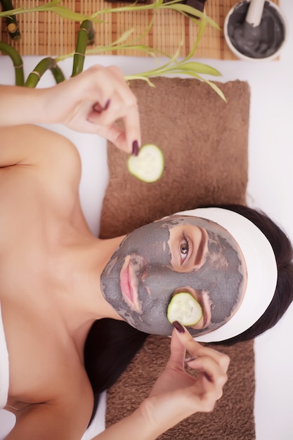 Aplicar máscara facial en la cara de una mujer en un salón de belleza