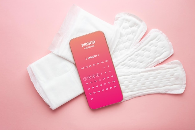 Aplicativo de calendário menstrual no telefone isolado sobre fundo rosa