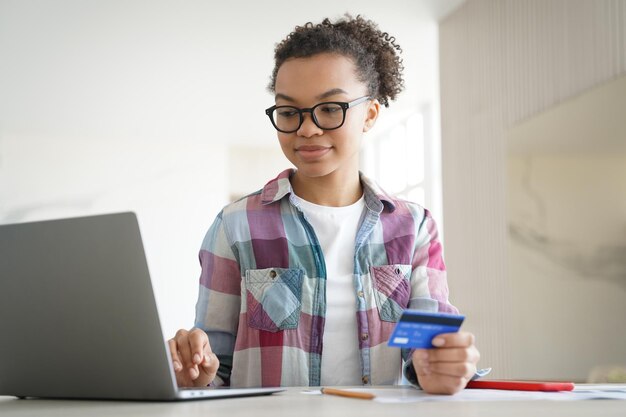 Aplicativo ou site de internet banking Adolescente feliz gasta dinheiro através da internet