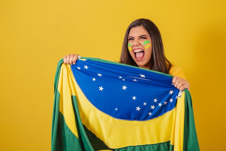 Foto apoiadora do campeonato de futebol da copa do mundo 2022 do brasil segurando bandeira gritando gol e comemorando comemorando