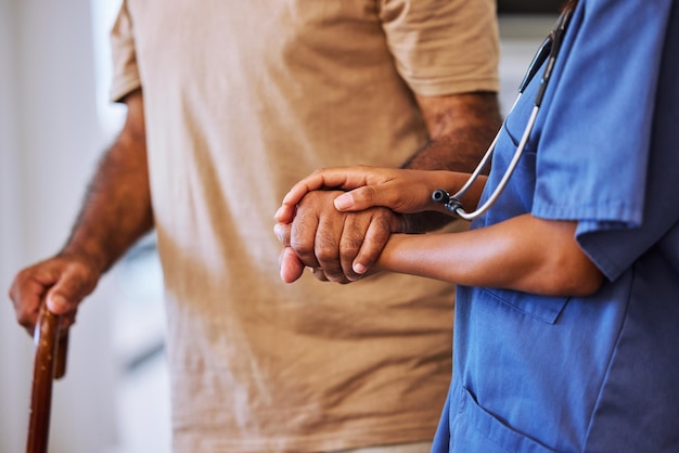 Apoiar a confiança e a ajuda do cuidador ou enfermeiro caminhando com um idoso ou paciente em casa de repouso com seguro de saúde Mãos de trabalhadora médica e alzheimer masculino com cuidados paliativos