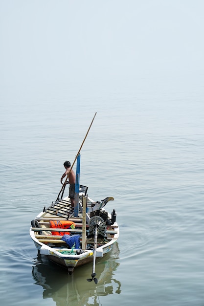 Apoiar uma canoa de madeira clássica no rio madura