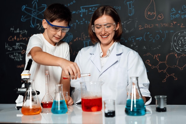 Foto apoio dos professores aos estudantes que misturam soluções em laboratório na aula de stem erudição