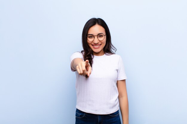 Apontando com um sorriso satisfeito, confiante e amigável, escolhendo você