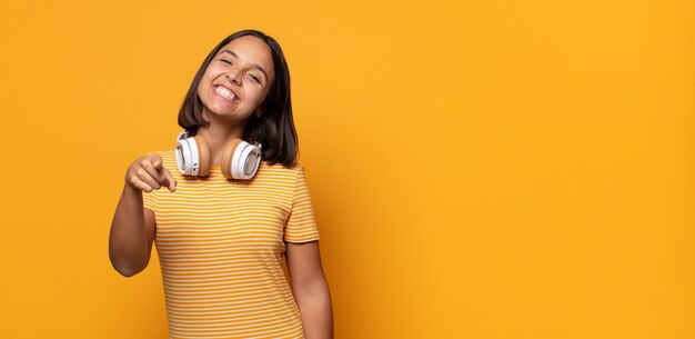 Apontando para a câmera com um sorriso satisfeito, confiante e amigável, escolhendo você