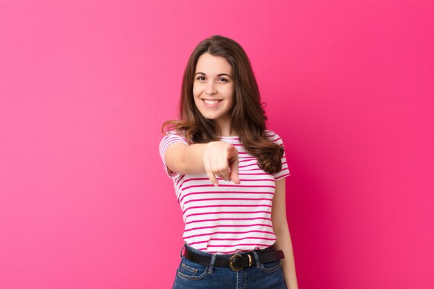 apontando para frente com um sorriso satisfeito, confiante e amigável, escolhendo você