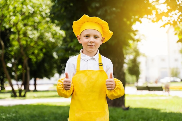 Aponte para a direita Bonita cozinheira com chapéu de chef amarelo e avental amarelo uniforme mostrando o polegar para cima Anúncio criativo para loja de comida e café