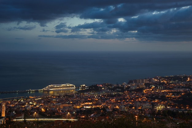 Após o pôr do sol vista panorâmica para o Funchal com o oceano atlântico e o navio de cruzeiro Madeira.