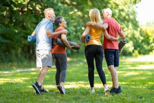 Aposentadoria ativa dois casais idosos treinando juntos no parque ao ar livre