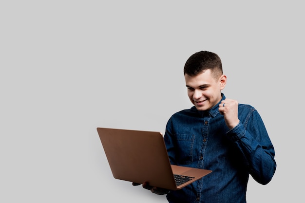 Aposta vencedora no casino online. Homem feliz com laptop ganha um prêmio. Estilo de vida luxuoso.