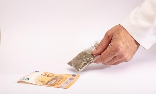 Apothekenangestellter liefert Taschengeld für medizinisches Marihuana auf weißem Tresen