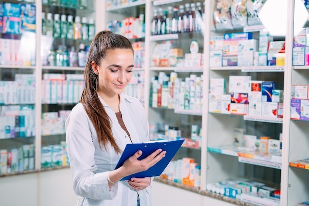 Apotheker-Chemikerin, die mit Tablet in der Apotheke arbeitet.