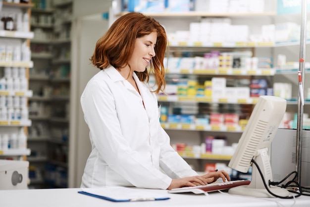 Apotheker Computer und Inventar für die Bestandsüberprüfung und Medikamente in der Apotheke Chemiker oder Dienstleistungen Weibliche Person Beratung und pharmazeutische im Laden für verschreibungspflichtige Pillen oder Informationen mit Tech