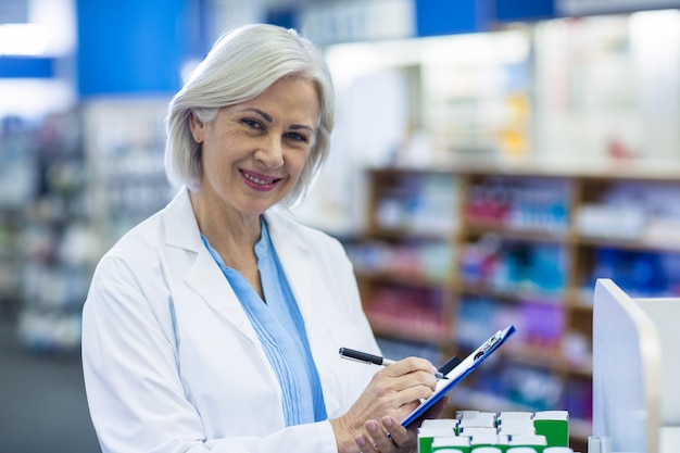 Apotheker, der auf Zwischenablage in der Apotheke schreibt