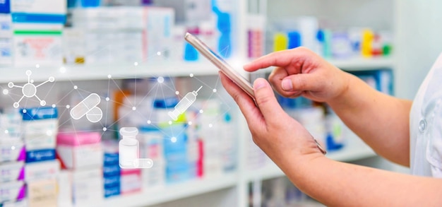 Apotheker mit mobilem Smartphone für die Suchleiste auf dem Display in der Apotheke