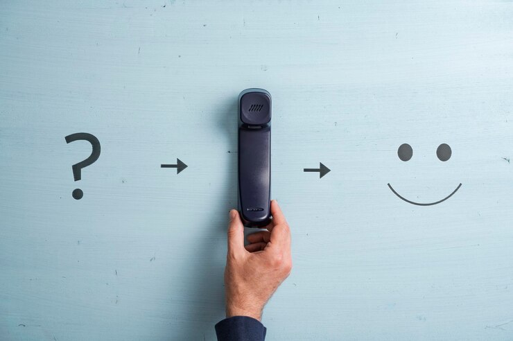 Foto apoyo al cliente y resolución de problemas imagen conceptual teléfono fijo negro colocado entre un signo de interrogación y una cara sonriente sobre fondo azul