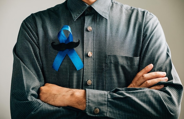 En apoyo de causas vitales, las manos de los hombres cuentan con una cinta azul con bigote que significa conciencia para el cáncer de colon, cáncer colorrectal, abuso infantil, día mundial de la diabetes y Día Internacional del Hombre.