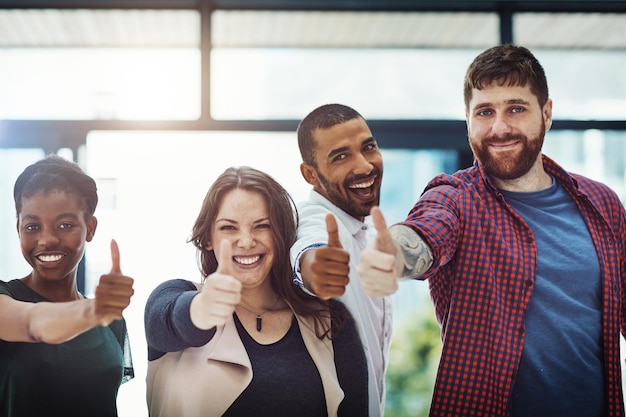 Foto apoyo y confianza en el trabajo en equipo con un pulgar hacia arriba de colegas felices que colaboran socios emocionados que se unen mostrando confianza y éxito con un gesto ganador comunidad trabajando juntos hacia un objetivo