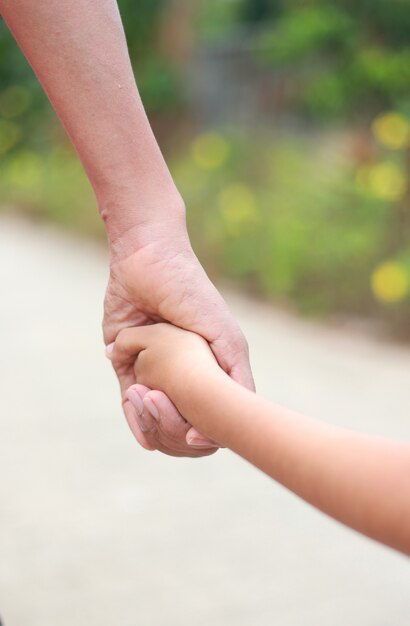 Apoyo familiar - padre agarra la mano del niño con amor