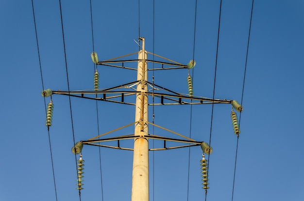 El apoyo de la línea eléctrica en el fondo del cielo azul.