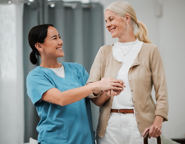 Foto apoyo para mujeres mayores y bastón para caminar con una enfermera tomándose de la mano para recibir ayuda por discapacidad o enfermería para la jubilación paciente anciano o persona discapacitada con un cuidador amigable en el hogar para el parkinson o la artritis