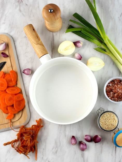 Foto apoyos de la comida bandeja de cerámica blanca vacía con ingredientes vegetales alrededor