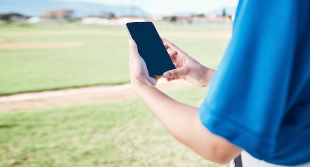 App-Feld und Person mit einem Telefon für Baseball-Informationen, die nach einem Spiel Punkte oder Ergebnisse lesen. Fitness-Hände und ein Athlet mit einem Mobiltelefon für die Trainingsverbindung oder das Streamen eines Wettbewerbs