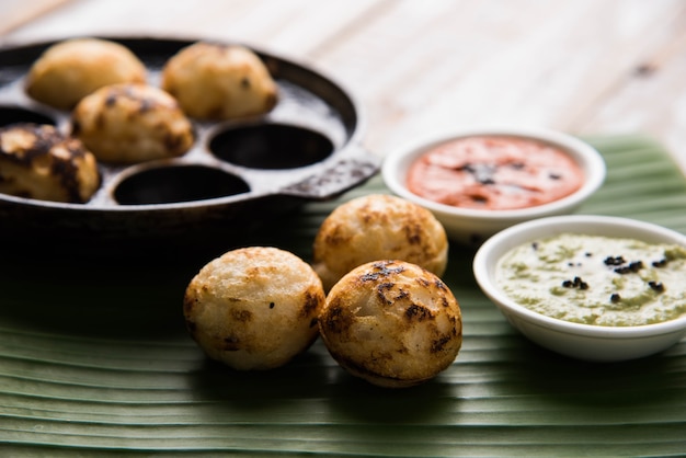 Appam o Mixed dal o Rava Appe servido sobre un fondo de mal humor con chutney verde y rojo. Receta de desayuno popular del sur de la India en forma de bola. Enfoque selectivo