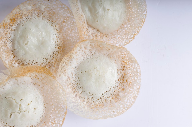 Appam oder velliappam oder kallappam oder paalappam, leckeres leckeres frühstück in südindien oder malabar, hergestellt aus rohem reis und eine gute kombination für vegetarische und nicht-vegetarische currys, auf einem weißen platziert