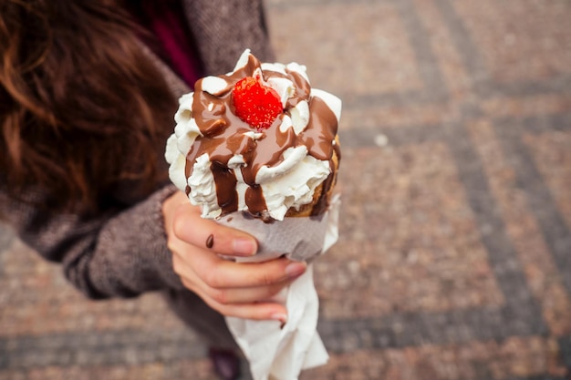 Appetit isst einen traditionellen tschechischen süßen Trdelnik mit Vanillecreme und Erdbeeren in der Prager Straße