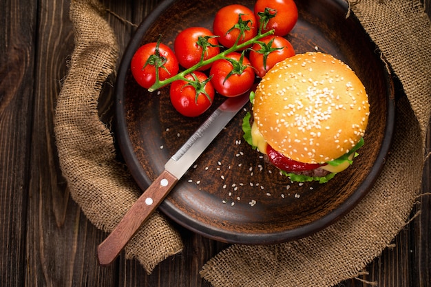 Appetitanregender Burger mit Tomaten auf Tabelle