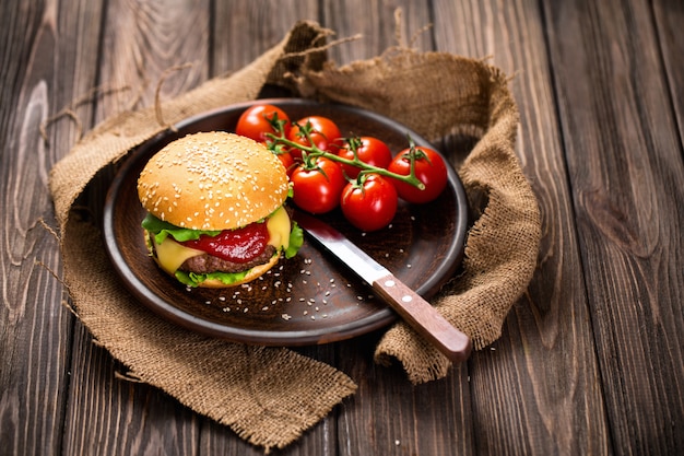 Appetitanregender Burger mit Tomaten auf Tabelle