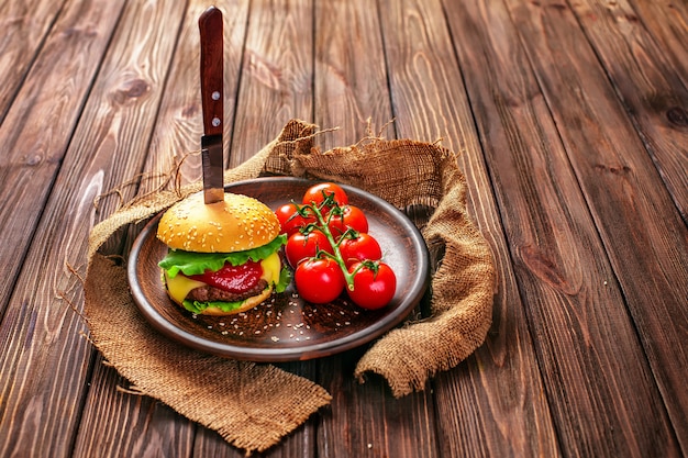 Appetitanregender Burger mit Tomaten auf Tabelle