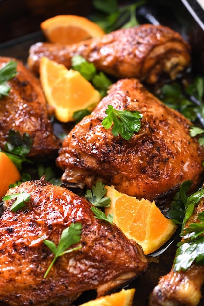 Appetitlich gebackene Hähnchenscheiben mit knusprig gebratener Kruste und Orangen in einem Backblech