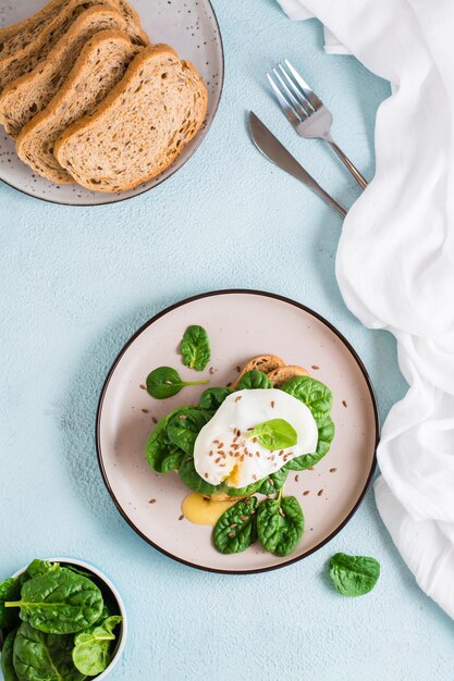 Appetitliche Bruschetta mit pochiertem Ei und Spinat auf einem Teller Keto-Diät Draufsicht und vertikale Ansicht