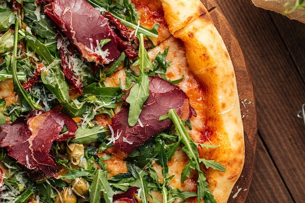 Appetitliche Gourmetpizza mit getrocknetem Pferdefleisch und Rucola