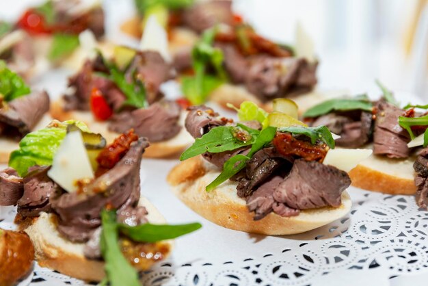 Appetitliche Häppchen mit Fleisch und Gemüse auf dem Buffettisch. Geschäftstreffen und Feiern. Nahaufnahme. Selektiver Fokus.