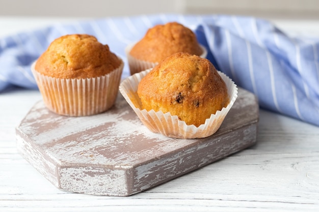 Appetitliche hausgemachte Muffins auf einem weißen Holztisch