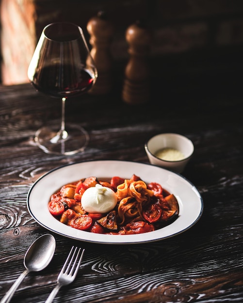 Appetitliche italienische Pasta mit Käse auf dunklem Holzhintergrund