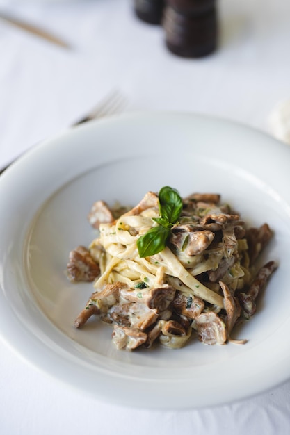 Appetitliche italienische Pasta mit Pilzen auf hellem Hintergrund.