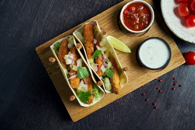 Appetitliche mexikanische Tacos mit Brathähnchen, Kohl, Zwiebeln und Petersilie an speziellen Ständen. Traditionelle mexikanische Küche