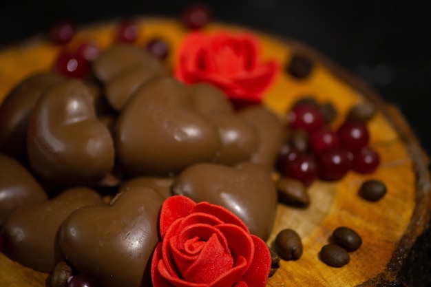 Appetitliche Pralinen auf dunklem Hintergrund Auf einem Holzschnitt Mit Blumen und Kaffeebohnen