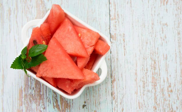 Appetitliche Scheiben reifer Wassermelone in einer weißen Schüssel auf dem Tisch