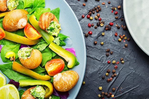 Appetitlicher Salat mit Spinat, Tomate, Pfeffer und Schnecken.