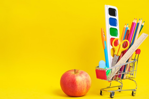 Apple-Briefpapier und Schulbedarf in einem gelben Hintergrund des Einkaufswagens