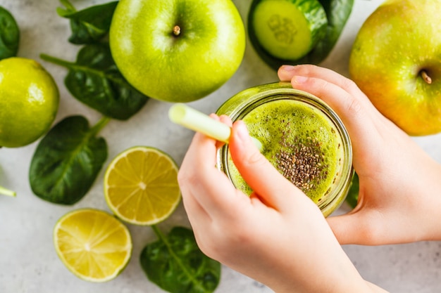 Apple, espinaca, batido de pepino en el fondo blanco con los ingredientes.