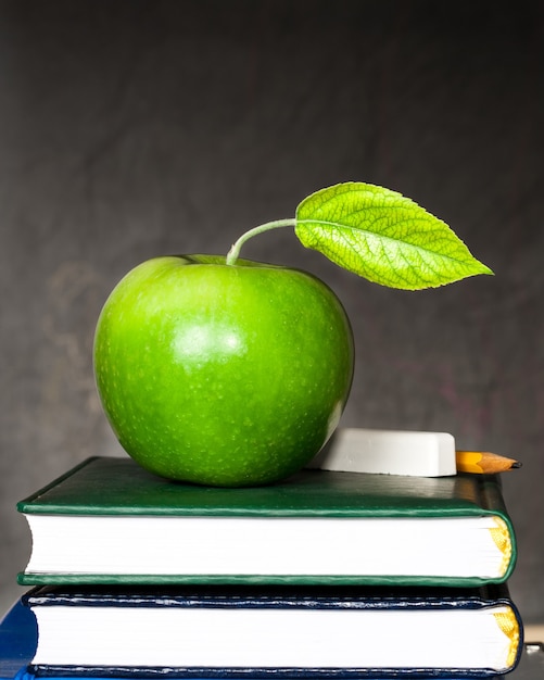 Apple, Kreide und Bleistift auf Lehrbüchern gegen Tafel mit Kopie cpase. Schulkonzept