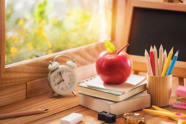 Apple legte ein Buch mit Bildungsgeräten am Fenster zum Morgenlicht, Back to School-Konzept und Kopierraum